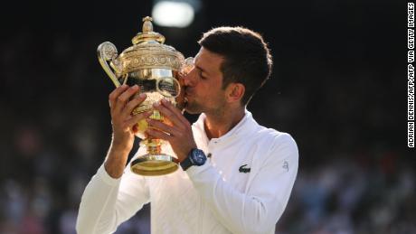 Novak Djokovic kisses the trophy after defeating Australia&#39;s Nick Kyrgios in the men&#39;s singles final at Wimbledon.