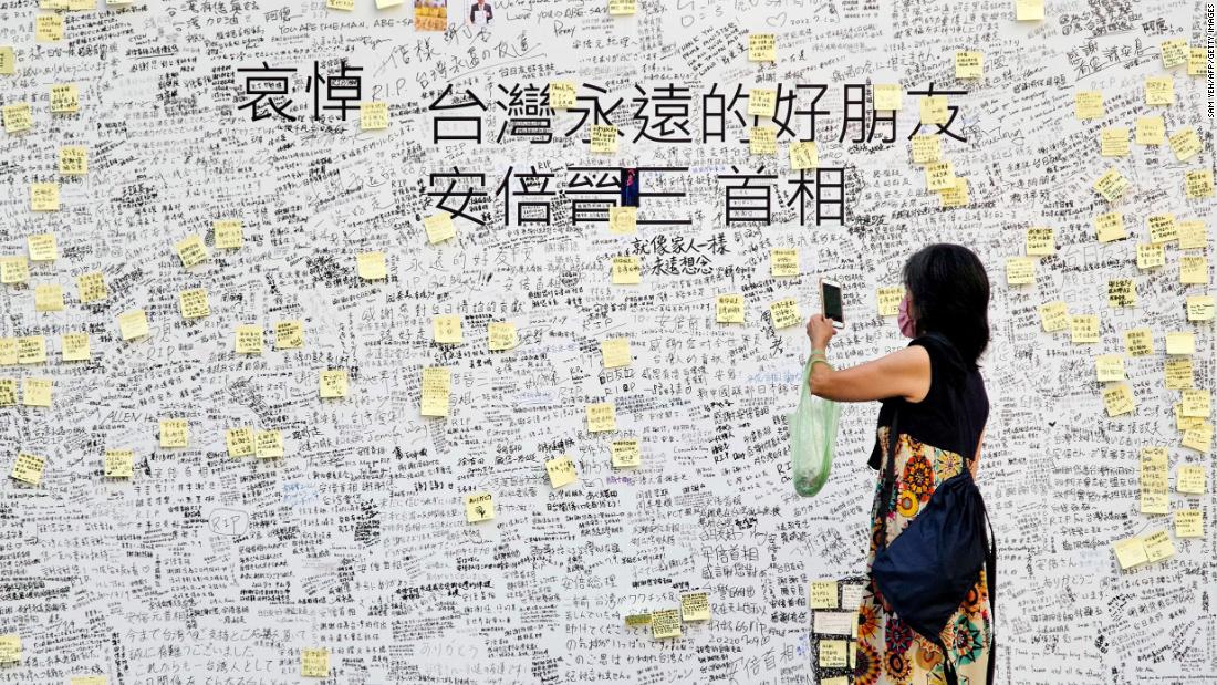 A woman takes a photograph of condolence messages for former Japanese prime minister Shinzo Abe in front of the Japan-Taiwan Exchange Association office in Taipei, Taiwan, on July 11.