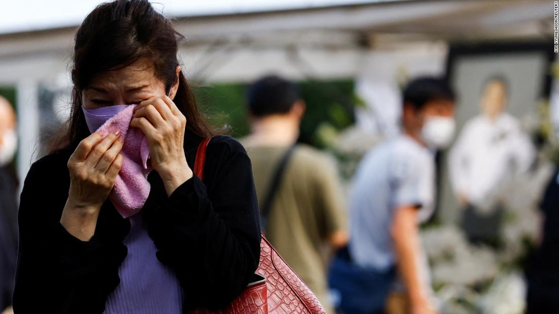 A mourner cries near a flower offering at Zojoji Temple, in Tokyo, Japan, on July 11.