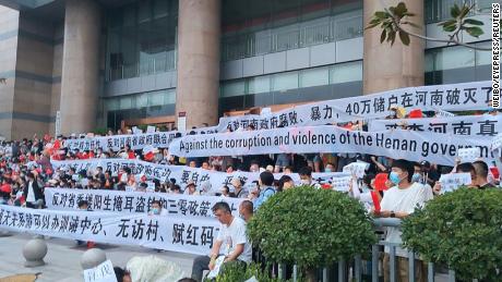 Over 3,000 Chinese demonstrators hold banners during a rare mass protest over the freezing of deposits by rural-based banks, outside a People&#39;s Bank of China building in Zhengzhou, Henan province, China July 10, 2022. 