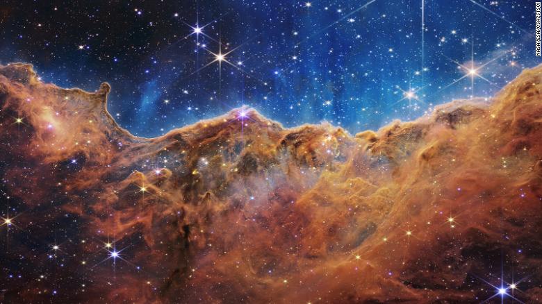 Webb's landscape-like view, called "Cosmic Cliffs," is actually the edge of a nearby, young, star-forming region called NGC 3324 in the Carina Nebula. The telescope's infrared view reveals previously invisible areas of star birth. 