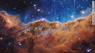 This landscape of &quot;mountains&quot; and &quot;valleys&quot; speckled with glittering stars is actually the edge of a nearby, young, star-forming region called NGC 3324 in the Carina Nebula. Captured in infrared light by NASA&#39;s new James Webb Space Telescope, this image reveals for the first time previously invisible areas of star birth. 