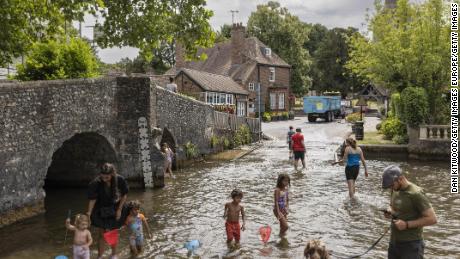 Families cool off in the River Darent on July 12, 2022 in Eynsford, United Kingdom. A level 2 heat health alert has been issued of the south and eastern parts of England.  (Photo by Dan Kitwood/Getty Images)