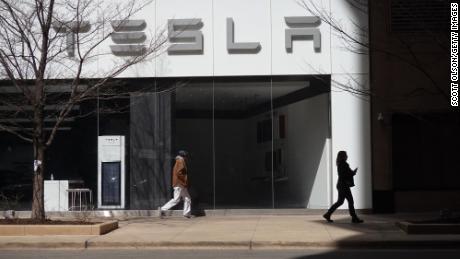 People walk into a downtown Tesla dealership on March 28, 2022 in Chicago, Illinois. 