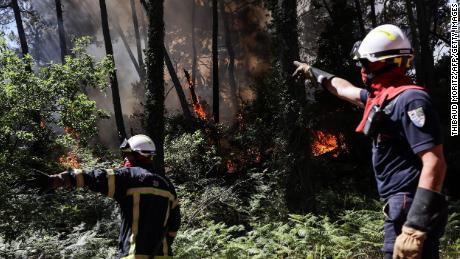 Los bomberos trabajan para extinguir un incendio forestal que estalló en el fondo de la Dune du Pilat cerca de Teste-de-Buch, en el suroeste de Francia, el 13 de julio.
