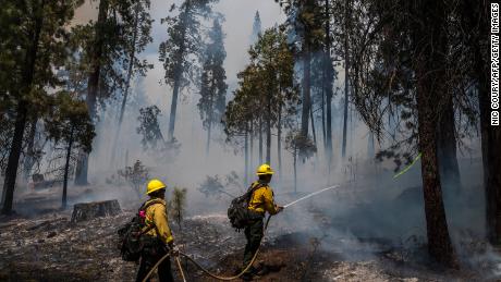 Firefighters put out hot spots from the Washburn Fire in Yosemite National Park earlier this week. The climate crisis has intensified deadly, costly wildfires in the West.