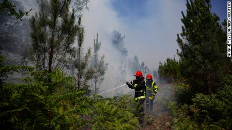 Firefighters work to contain a fire near Louchats, France, where the national weather agency issued an extreme heat alert. 