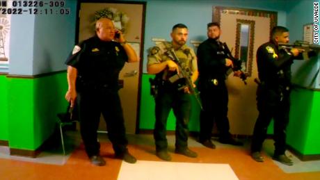 En esta captura de un video publicado por el alcalde de Uvalde, Don McLaughlin, el jefe de policía de la escuela de Uvalde, Pedro "Pete"  Arredondo, a la izquierda, habla por teléfono en el pasillo de Robb Elementary.