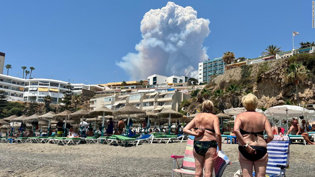 People look at plumes of smoke caused by a wildfire in Malaga, Spain, on July 15.