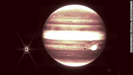 Jupiter, the center, and the moon Europa, on the left, are seen through the Web Telescope's NIRCam instrument.