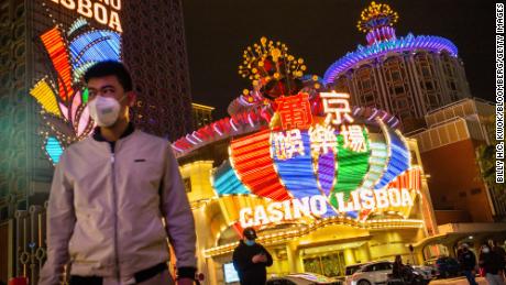 People wearing protective masks walk in front of SJM Holdings & # 39;  Casino Lisboa in Macau in March 2020. 