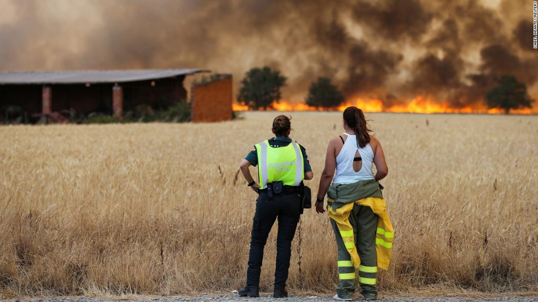 A firefighter and a member of Spain&#39;s Civil Guard watch a fire in Zamora, Spain, on July 18.