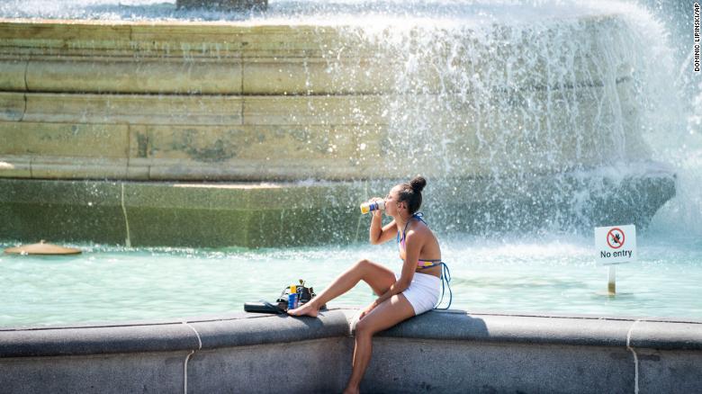 A woman sits by the fountains in Trafalgar Square in London on Tuesday.