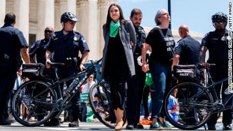 Rep. Alexandria Ocasio-Cortez, D-N.Y., center, is escorted away from a sit-in outside the Supreme Court with members of Congress to protest the decision to overturn Roe v. Wade on Tuesday, July 19, 2022.