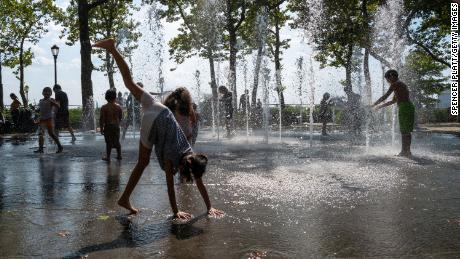 Children cool off in a fountain in Manhattan Tuesday.