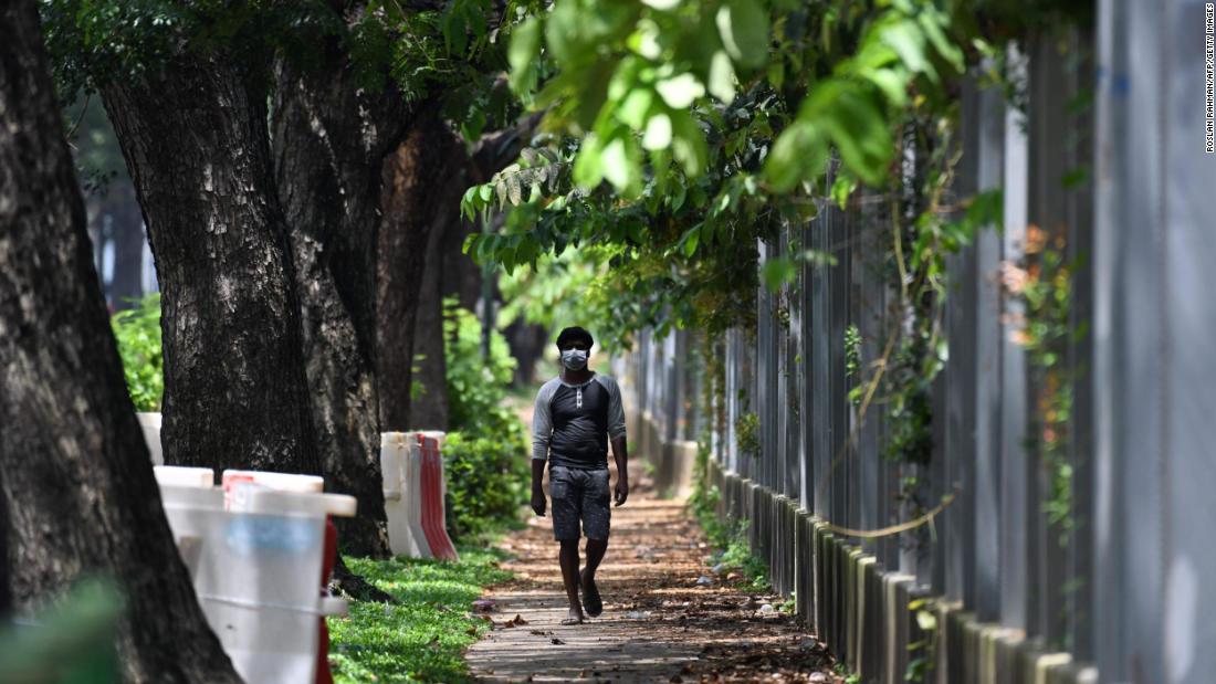 A worker walks by a foreign workers&#39; dormitory in Tuas, Singapore.