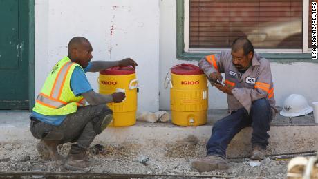 Construction workers Anthony Harris and Angel Gonzalez take a water break during an excessive heat warning in San Antonio, Texas, on Tuesday.
