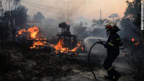 A firefighter tries to extinguish a blaze in Pallini, near Athens, Greece on July 20.