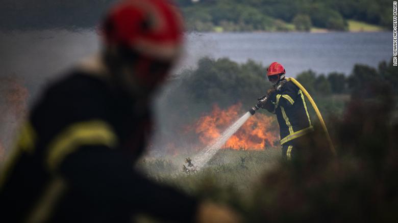 Firefighters spray water on a fire in Monts d'Arree, in Brittany, northwestern France.