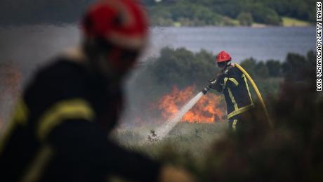 Bombeiros pulverizam água em um incêndio florestal em Monts d'Arree, na Bretanha, noroeste da França.
