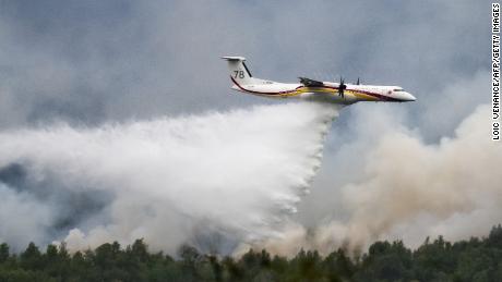 A De Havilland Canada Dash 8-400 MR aircraft drops water over a wildfire raging in the Monts d&#39;Arree, near Brennilis, Brittany, on July 20, 2022. - A heatwave fuelling ferocious wildfires in Europe pushed temperatures in Britain over 40 degrees Celsius (104 degrees Fahrenheit) for the first time after regional heat records tumbled in France. (Photo by LOIC VENANCE / AFP) (Photo by LOIC VENANCE/AFP via Getty Images)