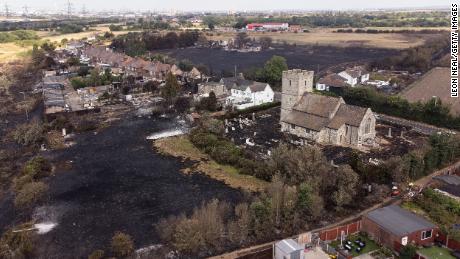 The scorched graveyard around a church following a large blaze in Wennington, east London, on Tuesday. The UK experienced a record-breaking heatwave this week.  