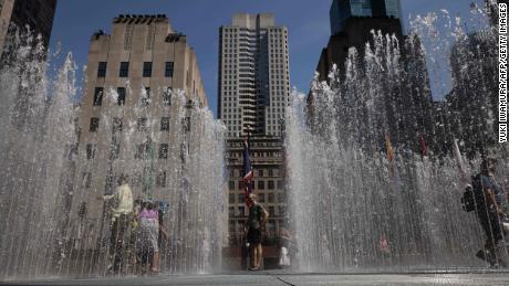 People play in the water sculpture at Rockefeller Center Plaza in New York on Tuesday.