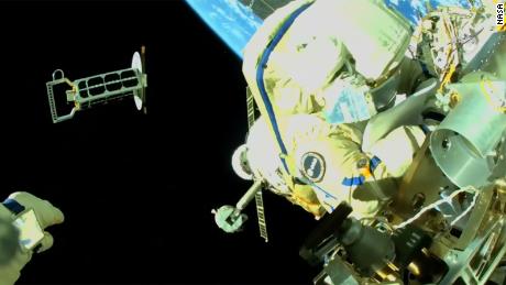 Cristoforetti is te zien aan de buitenkant van het internationale ruimtestation ISS, met de hand van Artemiev zichtbaar in de linkerbenedenhoek, die een nanosatelliet in een baan om de aarde lanceert. 