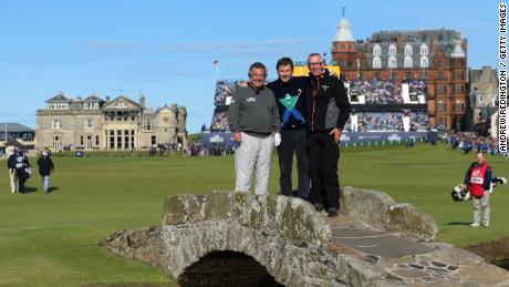 (LR) Les golfeurs anglais Tony Jacklin et Nick Faldo posent avec Cannon sur le pont Swilcan avant le 144e Open Championship à St Andrews, en Écosse, en 2015.