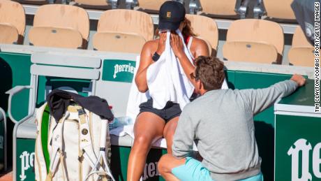 Naomi Osaka of Japan is consoled by coach Wim Fissette after finishing her training session early at the French Open Tennis Tournament on May 28, 2021 in Paris.