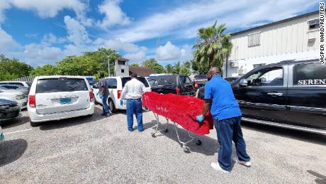 Jenazah salah satu korban tewas dibawa oleh petugas kamar mayat di Nassau. 