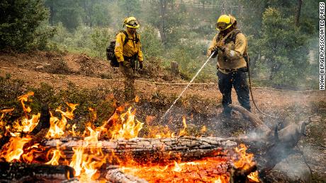 Firefighters clean up hotspots while fighting an oak fire in California.