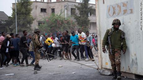 Congolese police officers oversee as protesters pull a container used to barricade the road near the warehouse compound of a United Nations peacekeeping force in Goma, North Kivu province in the Democratic Republic of the Congo, on July 26, 2022.