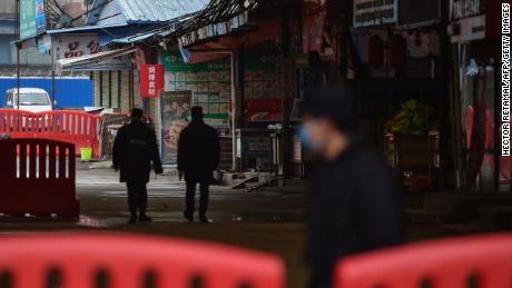 Security guards patrol outside the Huanan Seafood Wholesale Market where the coronavirus was detected in Wuhan on January 24, 2020 - The death toll in China&#39;s viral outbreak has risen to 25, with the number of confirmed cases also leaping to 830, the national health commission said.