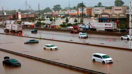 Abandoned cars are scattered by flooding across a shuttered section of I-70 Tuesday.