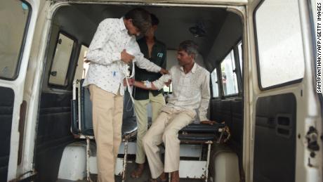 A man arrives at the Civil Hospital in Ahmedabad on July 26 after consuming bootleg liquor. 
