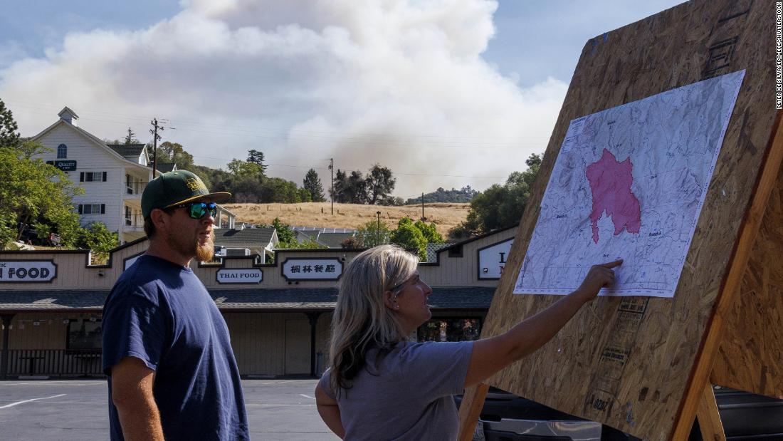 Local residents check a Cal Fire incident map in Mariposa on Saturday.