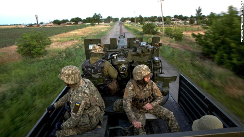 Ukrainian servicemen ride in a truck with cannon, as Russia&#39;s attack on Ukraine continues, in Mykolaiv Region, Ukraine June 15, 2022. 