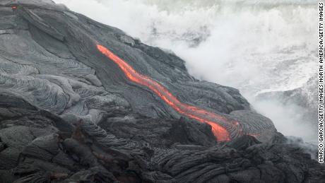 HAWAII - JUNE 6:  Lava flows into the ocean from Kilauea Volcano at Volcanoes National Park near Volcano, Hawaii June 6, 2004.  Lava from Kilauea has reached the ocean for the first time in nearly a year. (Photo by Marco Garcia/Getty Images)