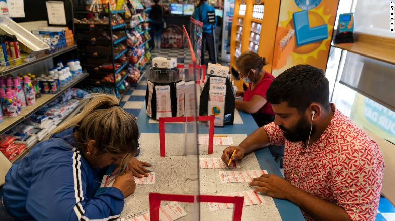 Nancy Linares, left, and Prince Joseph Israel, fill out Mega Millions play slips at Blue Bird Liquor in Hawthorne, California, Tuesday, July 26, 2022.