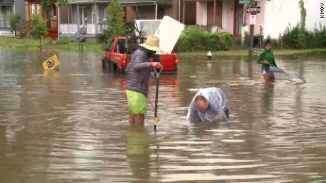 Residents try to clear a drain in St. Louis on Thursday. 