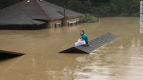 Uma menina de 17 anos nadou para fora de sua casa inundada com seu cachorro e esperou no telhado por horas para ser resgatada.