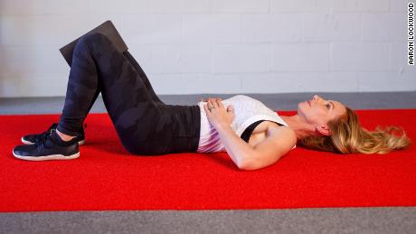 Bend your knees with a yoga block and place your hands on your lower ribs.