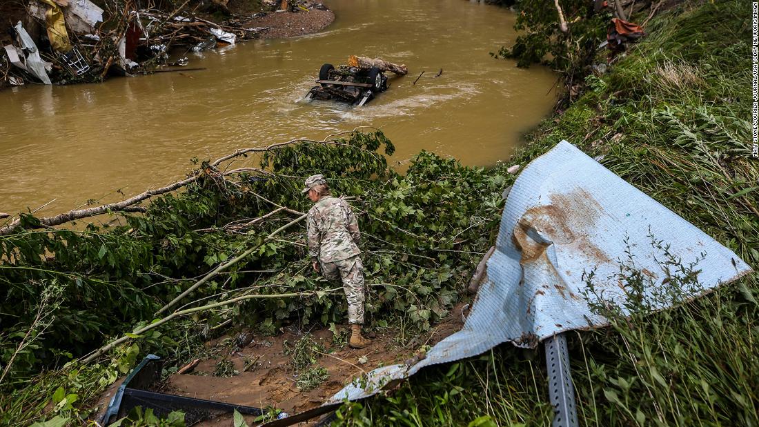 A member of the Kentucky National Guard looks for flood victims near a creek in Fisty, Kentucky, on Saturday. 