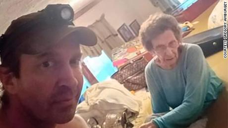 Gregory Ambergi é visto com sua avó Mae, de 98 anos, enquanto sua casa no leste do Kentucky é inundada.