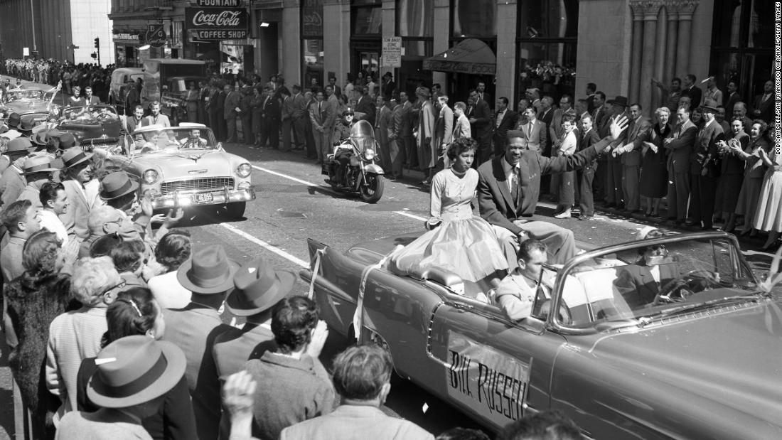 Russell and Rose Swisher wave to the crowd during a parade celebrating San Francisco&#39;s NCAA championship in San Francisco, California, in March 1955.