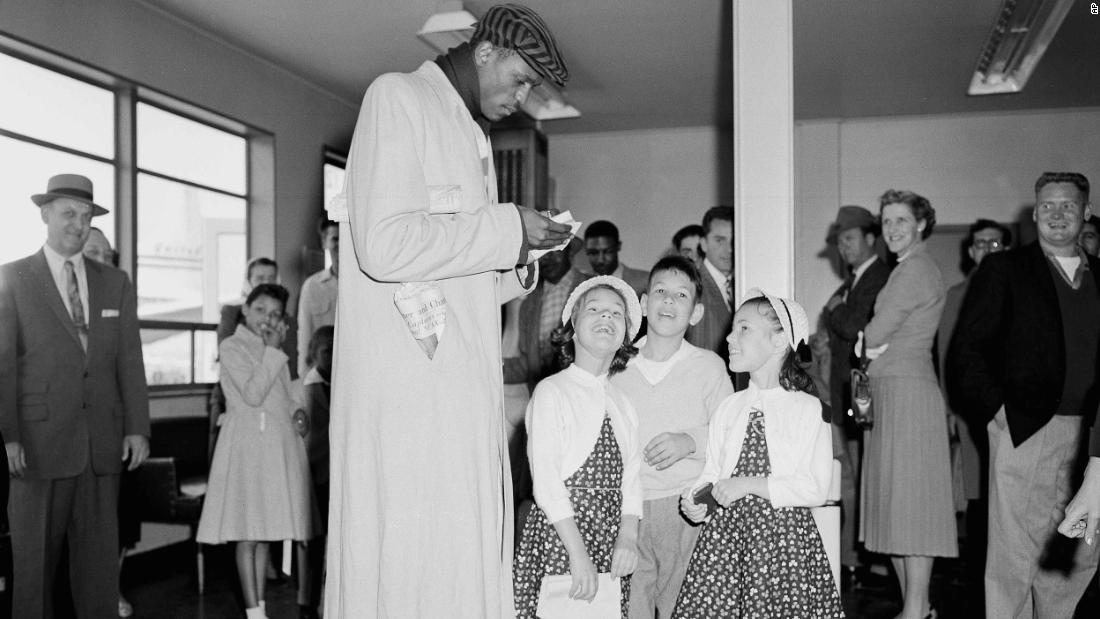 Russell signs autographs for young fans at San Francisco International Airport in March 1956.