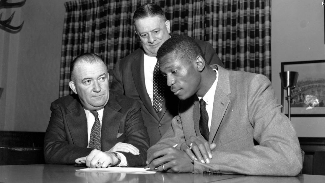 Joined by co-owners Lou Pieri and Walter Brown, Russel signs a contract to join the Boston Celtics in December 1956. Russell was selected second overall in the 1956 NBA draft by the St. Louis Hawks and was later traded to Boston.