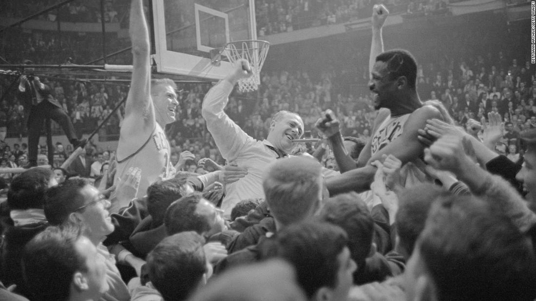 From left, fans carry then-Celtics forward Tommy Heinsohn, coach Red Auerbach and Russell around the court after Boston won their sixth consecutive NBA title in 1964.