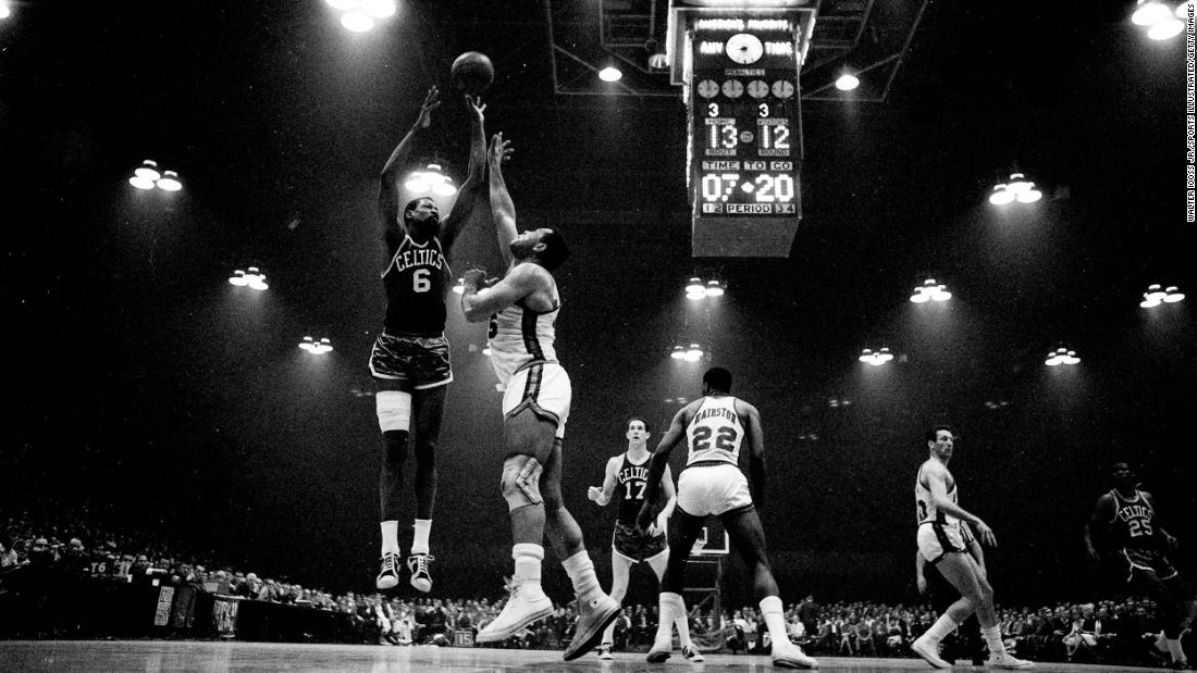 Russell, left, shoots over Cincinnati&#39;s Wayne Embry during a playoff game in Cincinnati, Ohio, in 1966. 